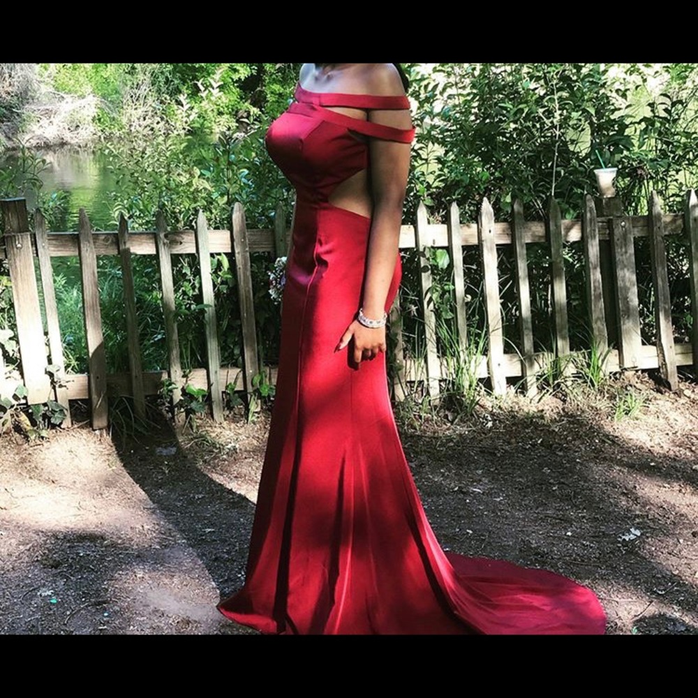 Beautiful backless red dress with long trail.